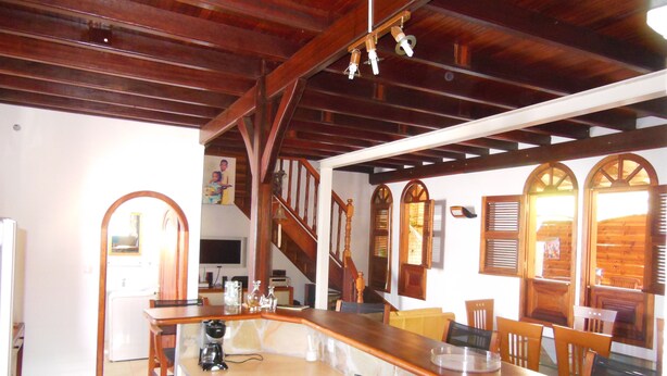 A kitchen with a wooden ceiling, a sink, and a countertop with various appliances.