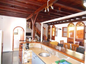 A kitchen with a wooden ceiling, a sink, and a countertop with various appliances. - Picturesque Holiday at sea in a small fishing village (LE CARBET)