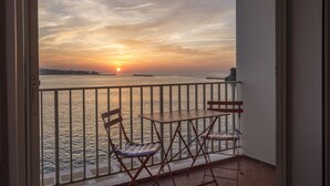 A balcony with a view of the sunset over the sea, featuring two chairs and a table. - Breathtaking sea view 1st ocean line - Contemporary decor (Saint-Jean-De-Luz)