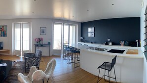 A modern living space with a sofa, a dining area, and a kitchen. - Breathtaking sea view 1st ocean line - Contemporary decor (Saint-Jean-De-Luz)