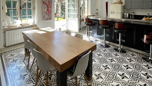 A modern kitchen with a large island, pendant lights, and a patterned floor. - TOWNHOUSE WITH SWIMMINGPOOL - Country living in the city (Nîmes)