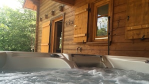 Uma cabana de madeira com hidromassagem e uma janela.