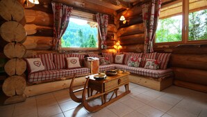 A cozy log cabin interior with a checkered sofa set, a wooden coffee table, and a fireplace. - Sublime chalet rondins de 140 m² en lisière de forêt et ruisseau, La Bresse, wifi (La Bresse)