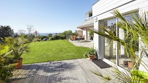 A modern house with a well-maintained lawn and patio area.