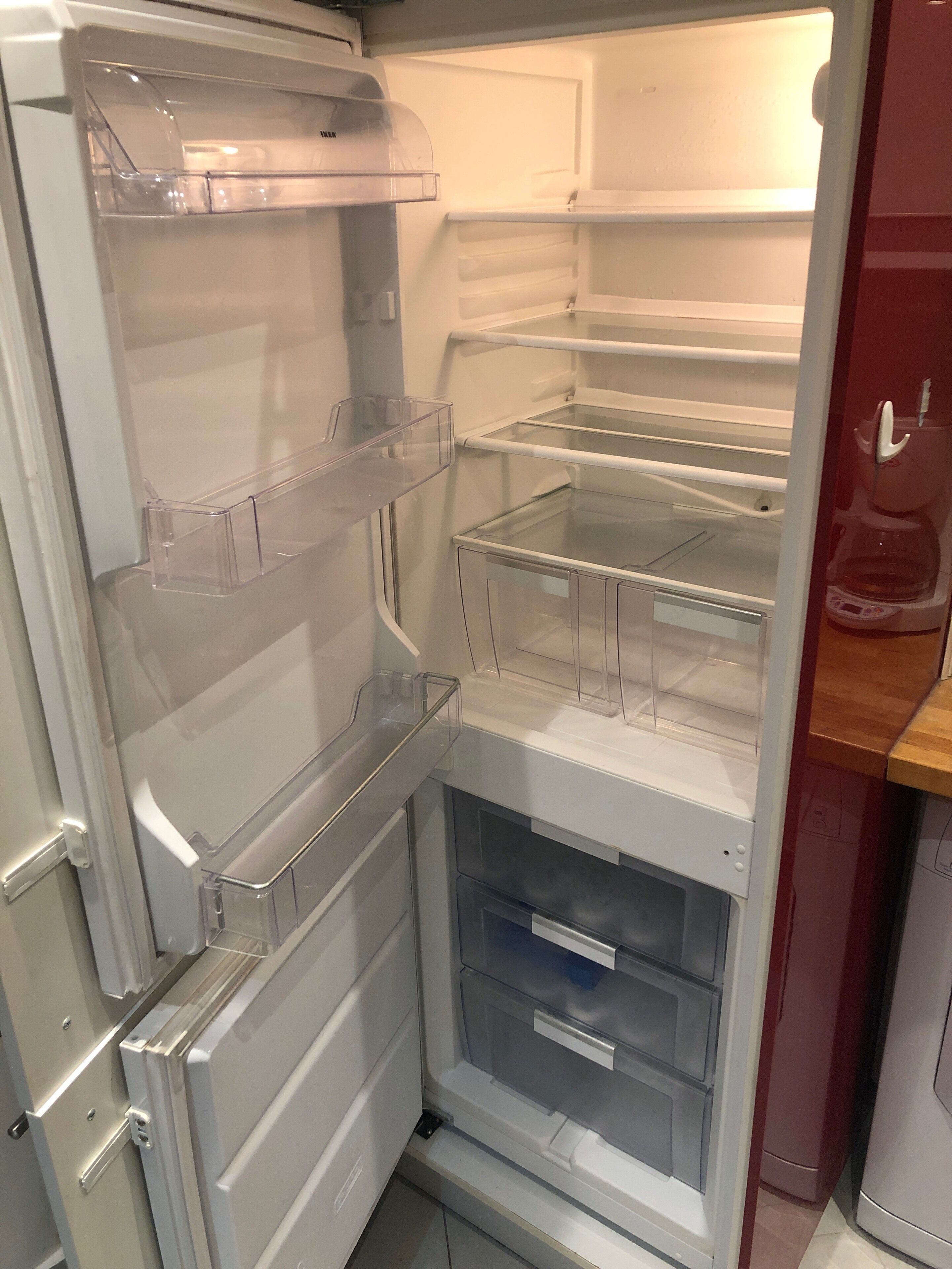 An empty refrigerator with multiple shelves and a freezer compartment.