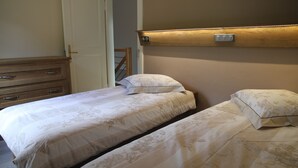 A bedroom with two beds, a wooden dresser, and a door. - Detached house in Metzeral for 8 to 10 people, in the Munster valley (Metzeral)