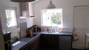 A compact kitchen with a dishwasher, a sink, and a window providing natural light.