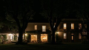 A two-story house with a well-lit front porch and a visible dining area. - In the Mas des Pampres, Provence is at your fingertips (Cabannes)