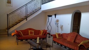 Una sala de estar con dos sofás rojos, una mesa de centro y una escalera.