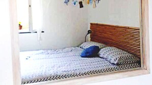 A bedroom with a bed, a hanging light fixture, and a wall-mounted clock. - The old mill (Rapallo)