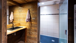 Un intérieur en bois comprenant un évier, une serviette et un espace douche.