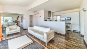 Een modern appartement met woonkamer, keuken en balkon.