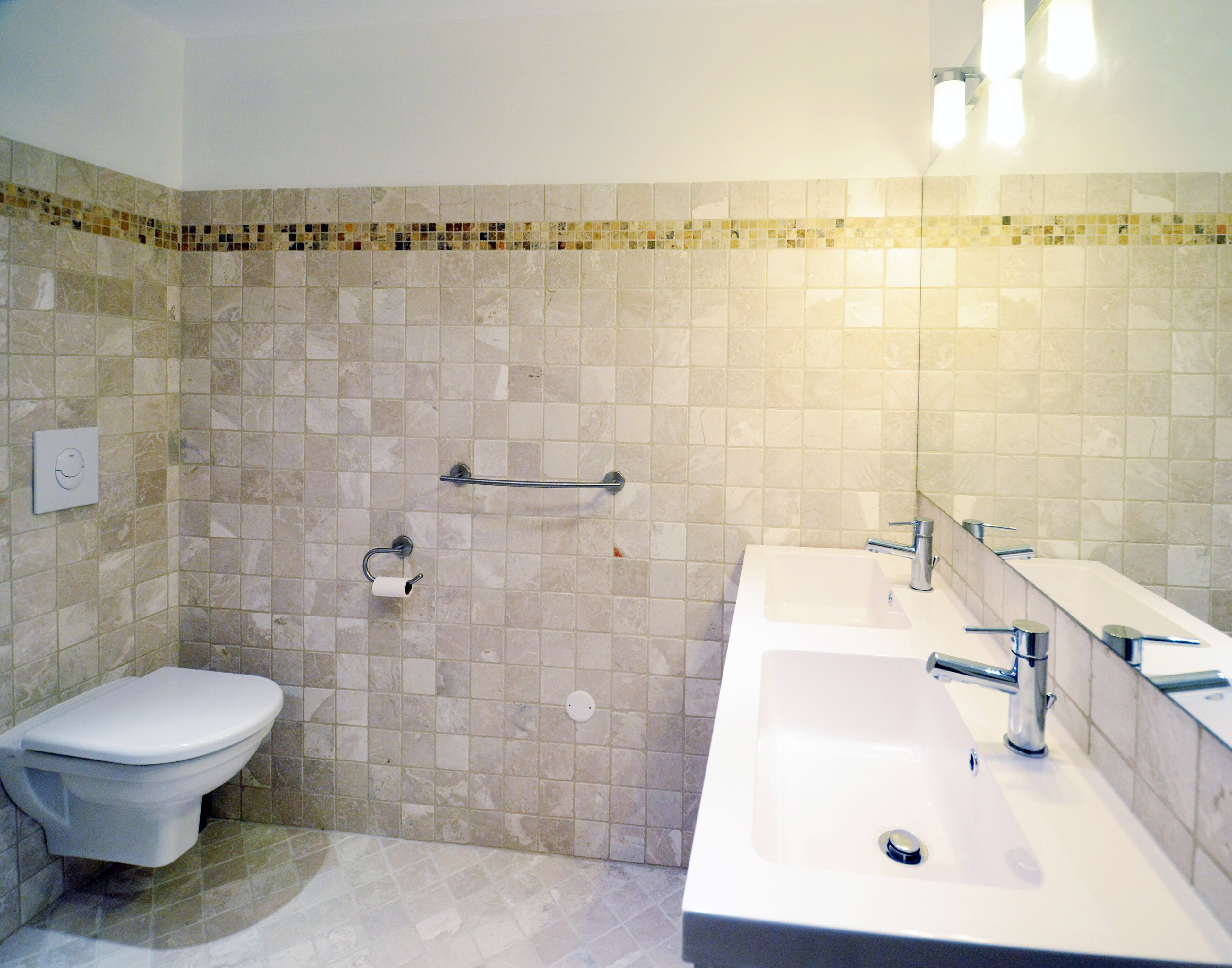 A bathroom with a toilet, sink, and shower area.