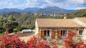 A stone building with a tiled roof, a hot tub, and a view of mountains. - Dry stone cottage with outdoor spa, quietness guaranteed (Granace)