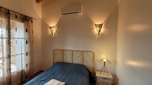 A bedroom with a bed, a nightstand, a lamp, and a window with curtains. - Dry stone cottage with outdoor spa, quietness guaranteed (Granace)