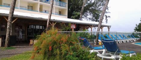 A hotel with a gym, outdoor seating, and a pool area.