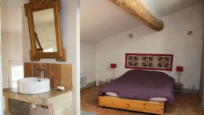 Una camera da letto con un letto in legno, un lavandino bianco e uno specchio.