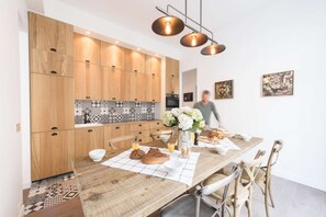 Eine moderne Küche mit Holzausstattung, einer zentralen Kochinsel mit Frühstückszubehör und Pendelleuchten.