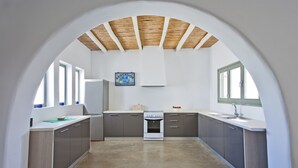 A modern kitchen with a central island, built-in appliances, and large windows.