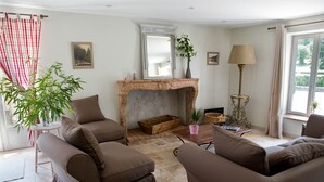 A living room with a fireplace, two sofas, a table, and a lamp.