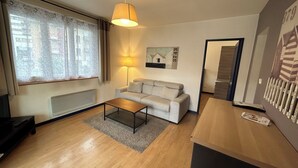 Ein modernes Wohnzimmer mit einer Couch, einem Couchtisch, einer Lampe und einem Bild an der Wand.