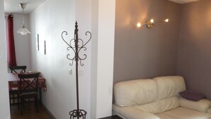 A living room with a white leather sofa, a small black table, and a floor lamp. - APARTMENT FOR 2 OR 3 PERS THONON CENTER (Thonon-Les-Bains)