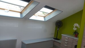 A bedroom with skylights, a bed, a desk, a dresser, and a fan. - APARTMENT FOR 2 OR 3 PERS THONON CENTER (Thonon-Les-Bains)