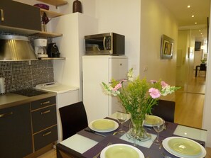 A modern kitchen with a microwave, refrigerator, and a dining area set for a meal.