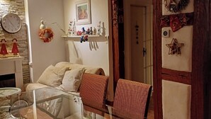 Ein Essbereich mit einem Glastisch und Stühlen, einer Holzzahlendecke und einer Wand mit verschiedenen Dekorationselementen.