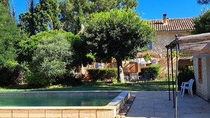 A pool area with a stone wall, a pergola, and outdoor seating. - Provençal farmhouse on a 20.000 sqm land, Mollégès, Provence. 5x10 m pool. (Mollégès)