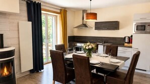 Una cocina moderna con comedor, chimenea y vistas al exterior.