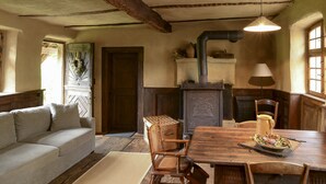 Un coin repas chaleureux avec une table en bois, des chaises en osier et un lustre.