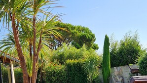 A poolside area with a table and two chairs, a bottle of wine, and a view of the pool. - house in provence between Saint Remy and Avignon with swimming pool for 6 people (Graveson)