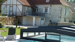 Ein Steinhaus mit Balkon, Schwimmbad und einer Steinmauer.