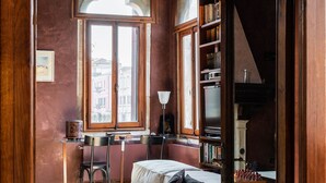Quarto aconchegante com uma cama, uma escrivaninha e uma estante de livros.