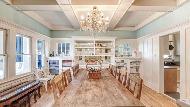 A dining room with a wooden table, chairs, a chandelier, and built-in shelves with glassware. - Clean & Spacious-Walk to the Fairmont, great restaurants, coffee shops and wine (Sonoma)
