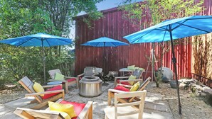 A patio with wooden chairs and tables, blue umbrellas, and a fire pit. - Clean & Spacious-Walk to the Fairmont, great restaurants, coffee shops and wine (Sonoma)