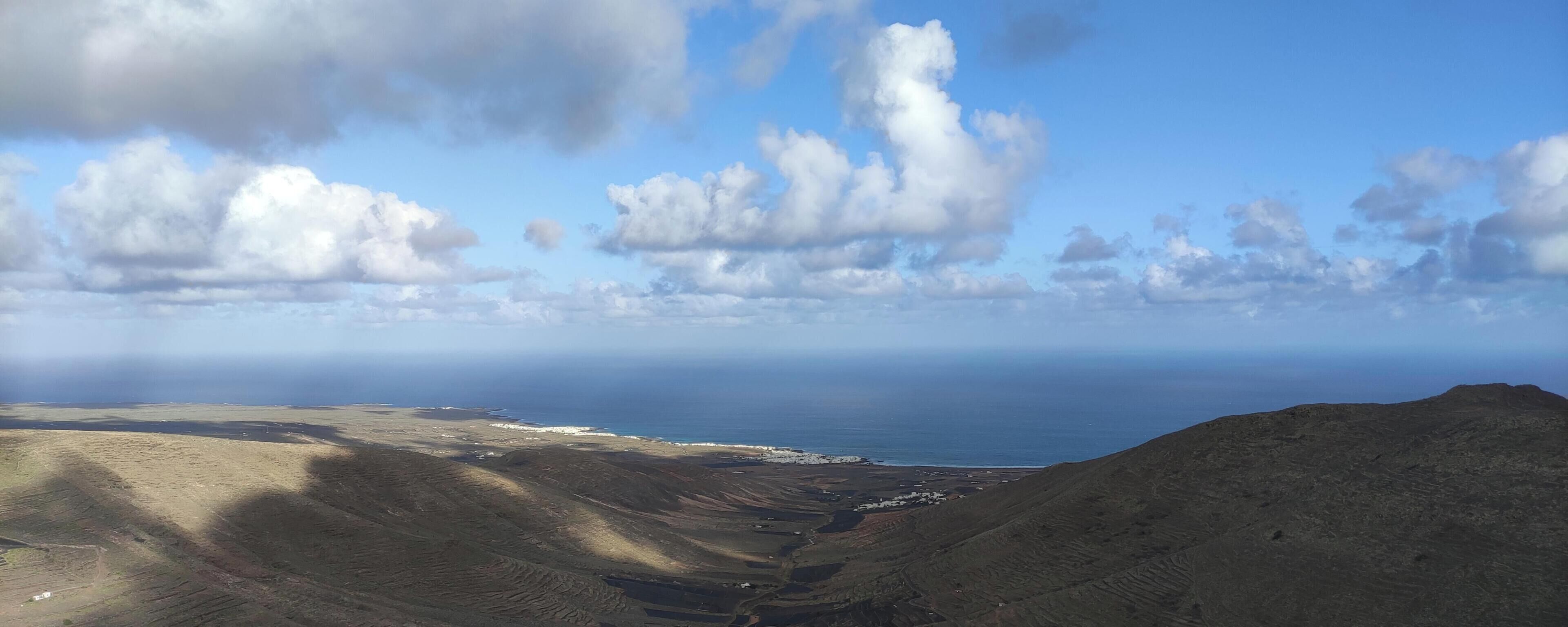 Een bergachtig landschap met uitzicht op de kust.