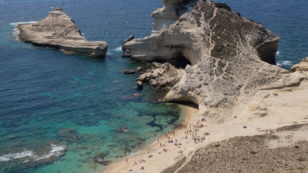 A coastal beach with clear waters, rocky formations, and a sandy shore. - Modern mini villa T3 800 m from the beach - all comforts, air conditioning, terrace (Lecci)