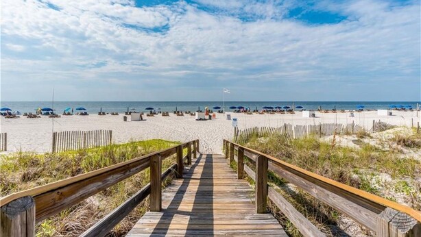 A wooden boardwalk leading to a beach with umbrellas and lounge chairs. - Perfect Family or Romantic Getaway~Best View in Orange Beach~Summer specials (Orange Beach)
