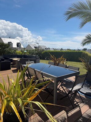 Eine Terrassengruppe mit Tisch, Stühlen und Blumentöpfen.