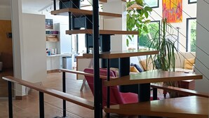 Ein modernes Interieur mit einer Holztreppe, einem Essbereich und Blick ins Freie.
