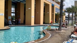 A swimming pool area with a pool, lounge chairs, and palm trees.
