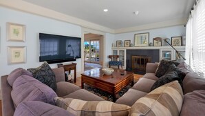 A living room with a large flat-screen TV, a fireplace, and a sofa set. - “Blue Door Cottage by the Sea,” La Jolla Village & Cove, Only 4 blocks to Beach  (La Jolla)