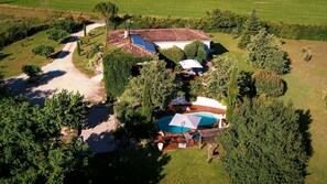 An aerial view of a property with a swimming pool, solar panels, and a covered outdoor seating area. - Villa Magarre - Heated pool - Spa - Nature (Castelnau-de-Montmiral)