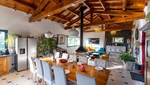 Una cocina amplia con electrodomésticos modernos, un comedor con mesa y sillas de madera, y una sala de estar acogedora con sofá y chimenea.