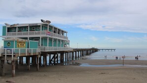 Un muelle de varios pisos con un bar y restaurante en la planta baja, que se adentra en el agua.