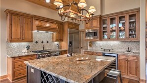 A spacious kitchen with wooden cabinets, a large island, stainless steel appliances, and a chandelier. - "Lovely Lookout" Ski, Golf & Club Amenities Schaffer's Mill, Lake Tahoe (Truckee)