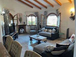 A living room with a fireplace, a sofa, a coffee table, and a television. - Independent villa, magnificent sea view, private swimming pool, WIFI (ALGARROBO)