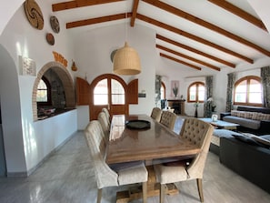 Un espace repas comprenant une table et des chaises en bois, un luminaire suspendu et une cheminée.